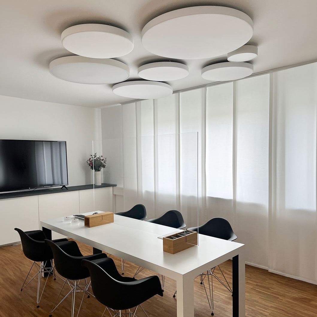Runde Akustikpaneele an der Decke in einem Besprechungraum über dem Tisch
